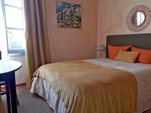 a bedroom with a bed and a table and a window at Chambre d'hôte Farniente in Aigues-Mortes