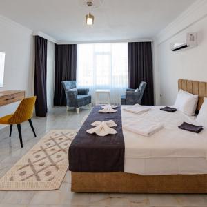 デムレにあるBo homes suıt apartの大きなベッドとデスクが備わるホテルルームです。