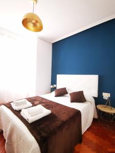 サラマンカにあるApartamentos Gran Viaの青い壁のベッドルーム1室(大型ベッド1台付)