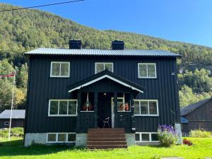 a black house with a mountain in the background at Nørdre-Repp in Boverdalen +16 photos