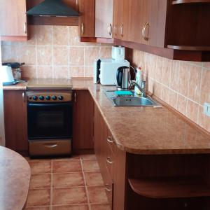 a small kitchen with a sink and a stove at 2 room apartment 350 m from sea in Liepāja