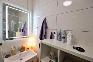La salle de bains blanche est pourvue d'un lavabo et d'un miroir. dans l'établissement PRAHA - SULICE, à Sulice