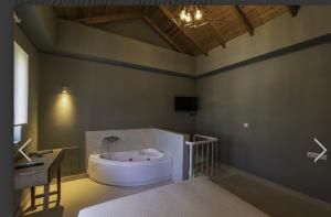 a bathroom with a bath tub and a sink at Anthelia in Skala Potamias