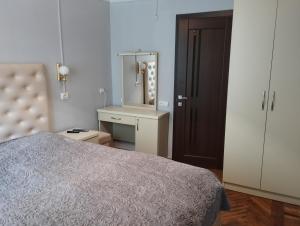 a bedroom with a bed and a dresser and a mirror at Tsovella House in Jermuk