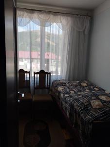 a bedroom with a bed and a large window at Tsovella House in Jermuk