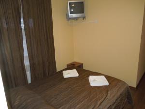 a hotel room with a bed and a tv on the wall at Motel Sapnis in Jēkabpils