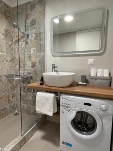 een badkamer met een wasmachine en een wastafel bij «ΑΓΝΑΝΤΙΟ l» Δωμάτιο με μοναδική θέα! in Mirina