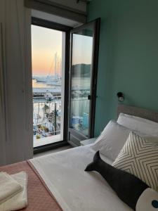 Schlafzimmer mit einem Bett und Blick auf den Yachthafen in der Unterkunft «ΑΓΝΑΝΤΙΟ l» Δωμάτιο με μοναδική θέα! in Mirina