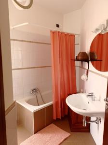 ein Badezimmer mit einem orangefarbenen Duschvorhang und einem Waschbecken in der Unterkunft Le tre punte in Scarperia