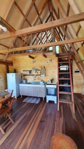 una cocina grande en una cabaña de madera con una escalera en Chalé da Pedra na Mantiqueira, en Pedra Bela