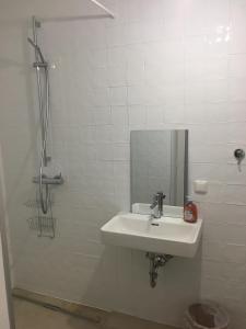 bagno bianco con lavandino e specchio di Apartment zur schönen Sophie a Gmunden