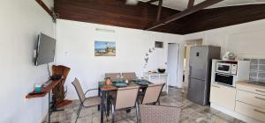 a kitchen with a table and chairs in a room at villa marie eugenie in Les Trois-Îlets