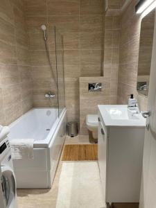 bagno con vasca, lavandino e servizi igienici di Shi Zi Junior Suite a Iaşi