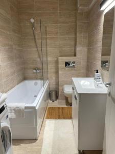 a bathroom with a tub and a sink and a toilet at Shi Zi Junior Suite in Iaşi