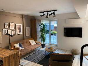 uma sala de estar com um sofá e uma televisão em Shi Zi Junior Suite em Iaşi