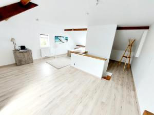 Habitación en el ático con paredes blancas y suelo de madera. en Studio Autonome Mont Saint Guibert en Mont-Saint-Guibert