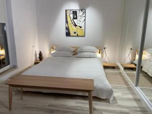 a bedroom with a large white bed and a table at Shi Zi Junior Suite in Iaşi