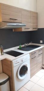 a kitchen with a washing machine and a sink at Studio chez Thomas in Paris