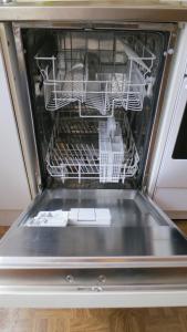 an open dishwasher with dishes inside of it at Alsfelder Apartment I in Alsfeld