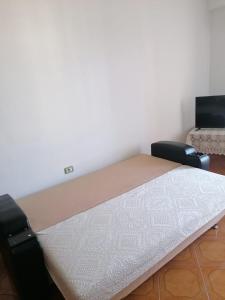 Bett in einem Zimmer mit 2 Stühlen in der Unterkunft Appartamento incantevole con posto auto privato in Vlorë