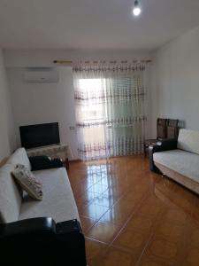 ein Wohnzimmer mit Sofa und Tisch in der Unterkunft Appartamento incantevole con posto auto privato in Vlorë