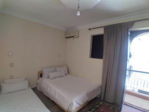 1 Schlafzimmer mit 2 Betten und einem Fenster in der Unterkunft Riad 9 Derb El Bousnne in Marrakesch