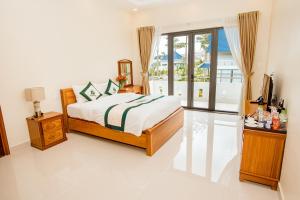 1 dormitorio con 1 cama y TV en Thuy Hoang Nguyen Resort & Spa, en Da Lat