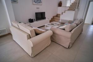 a living room with two couches and a tv at Casa Margherita - typical salento house in Castrignano del Capo