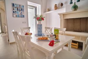 a white table with a plate of food on it at Casa Margherita - typical salento house in Castrignano del Capo