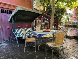 a table and chairs with a table and a umbrella at The house of the botanist in Tbilisi City