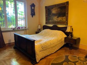 een slaapkamer met een bed en een schilderij aan de muur bij The house of the botanist in Tbilisi City