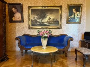 a living room with two blue couches and a table with flowers at The house of the botanist in Tbilisi City
