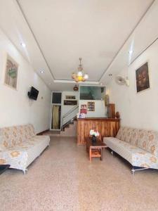 a living room with two couches and a table at Hom pho guesthouse in Ban Houayxay
