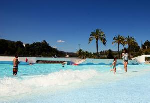 a group of people playing in the water at a swimming pool at Zen Guest House em Leiria in Pedrógão Grande