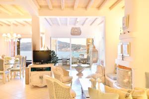 a living room with a tv and a table and chairs at Aegean Pearl in Ornos