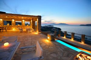 a house with a deck with a view of the water at Aegean Pearl in Ornos