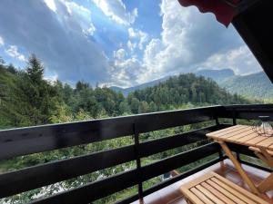 uma varanda com uma mesa e vista para as montanhas em Dolar Rooms em Bled