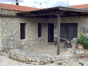 a stone house with a patio with chairs on it at Εθιά Παραδοσιακή πετρόχτιστη οικία EthiaTraditionalhouse of stone in Ethiá