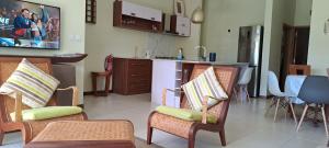 a living room with two chairs and a kitchen at Les Villas Thorel in Rivière Noire
