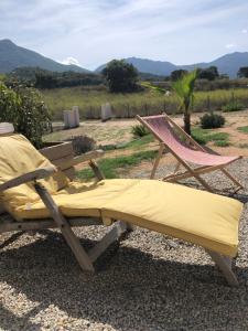 a hammock and a chair with a view of a field at Villa Jade in Sartène