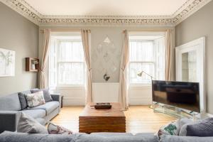 a living room with a couch and a tv at 2 Bed Old Town Apartment - Next To Castle in Edinburgh