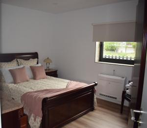 una camera da letto con un letto con cuscini rosa e una finestra di Giesteira's House a Arcos de Valdevez