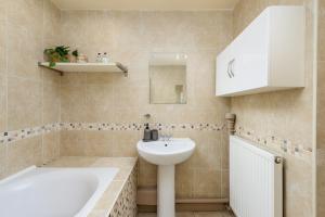a bathroom with a sink and a bath tub and a sink at 2 Bed Old Town Apartment - Next To Castle in Edinburgh