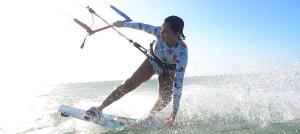 a woman is on a board in the water at Pousada farol in Areia Branca