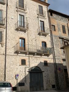 duży ceglany budynek z balkonami i drzwiami w obiekcie Coccinella San Marco w mieście Pacentro