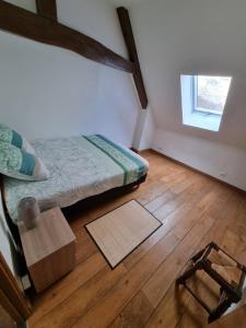 1 dormitorio con 1 cama y suelo de madera en Appartement familial avec balcon, en Trosly-Breuil