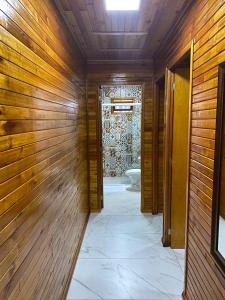 un corridoio con pareti in legno e servizi igienici in bagno. di Águia Dourada Hospedagem Casa 02 a Bom Jardim da Serra