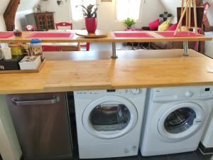 een keuken met een wasmachine onder een aanrecht bij Appartement familial avec balcon in Trosly-Breuil