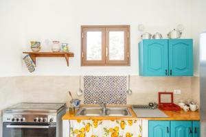 una cocina con armarios azules y fregadero en Cantunera Barbára, en Torre Nubia