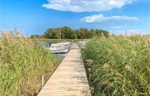 a wooden dock with boats on a body of water at Amazing Home In Gamleby With Wifi And 1 Bedrooms in Gamleby